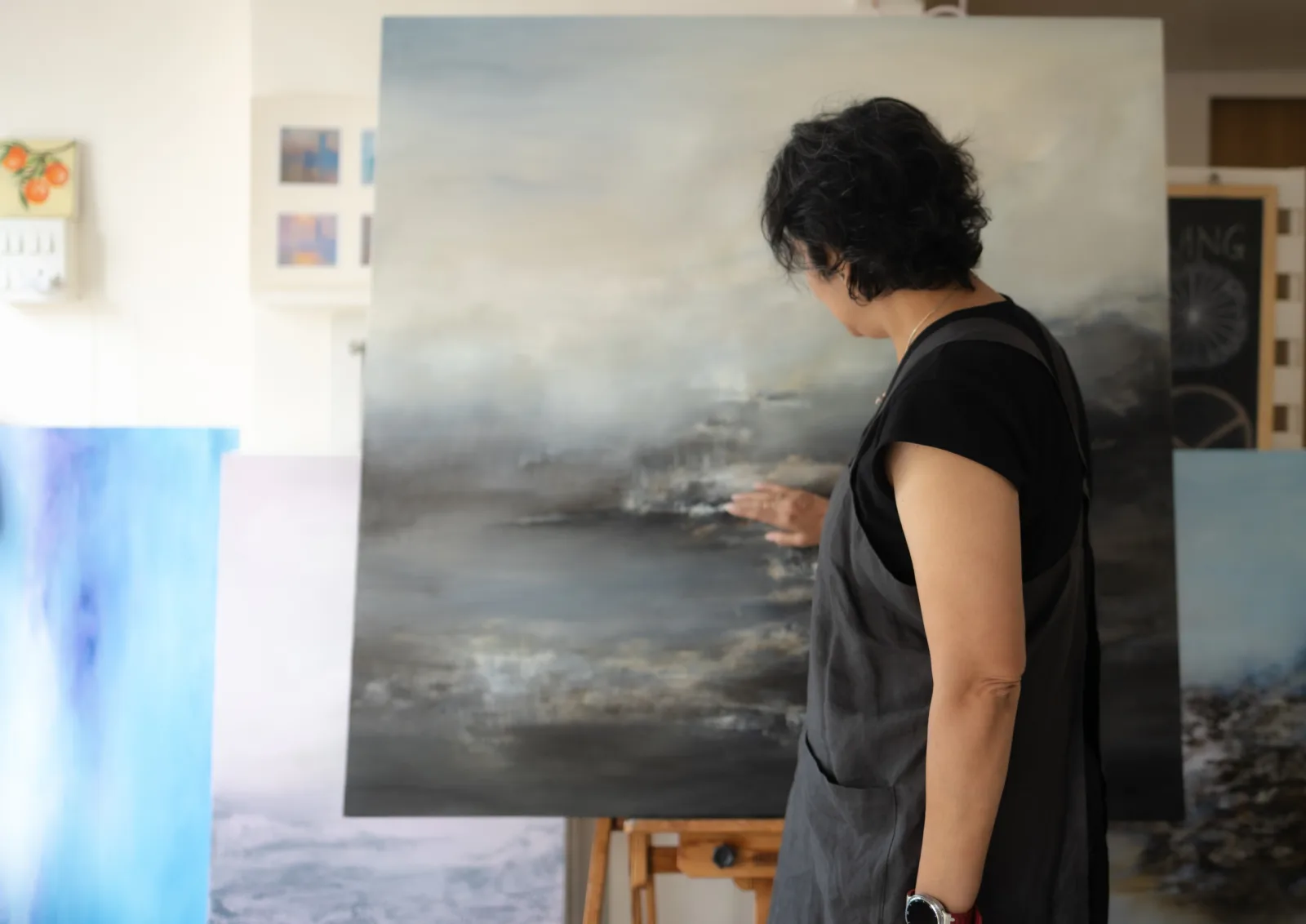 The artist working close to the canvas, hand to the surface